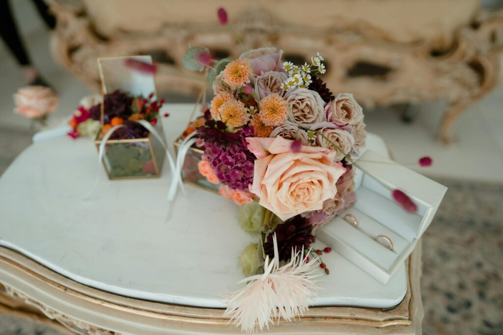 A beautifully arranged bouquet and wedding rings on a table set for an elopement ceremony. — Vegas elopement planning