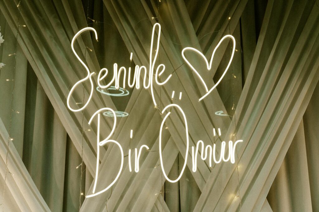 A charming wedding scene at The Neon Boneyard, highlighting vintage signs as a backdrop for a unique wedding photo. — ou…