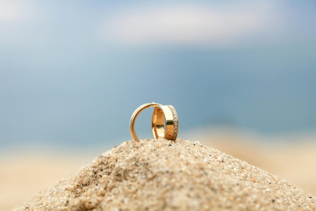 A close-up of wedding rings on a sandy beach, symbolizing love and commitment. — destination beach wedding Las Vegas