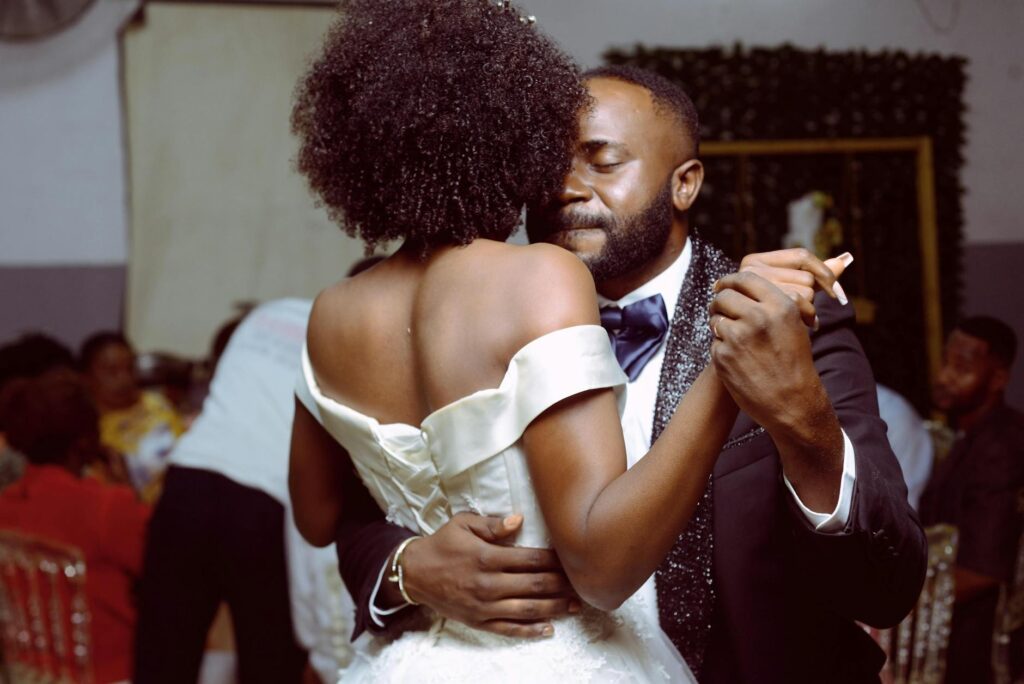 A couple dancing at their wedding with a playlist setup visible in the background. — affordable wedding entertainment La…