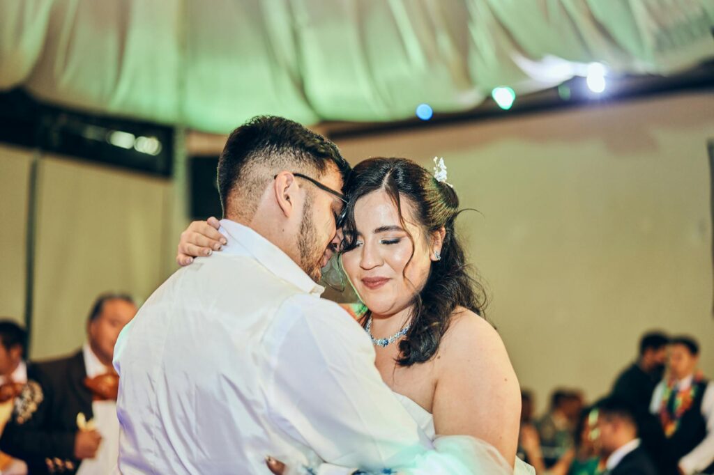 A couple enjoying their first dance at a casino-themed wedding venue with vibrant lights. — casino wedding entertainment…