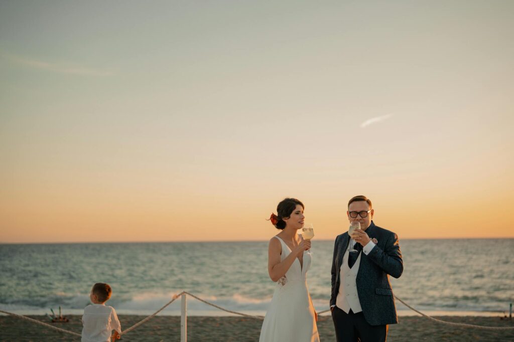 A couple exchanging vows on the beach under a sunset in Las Vegas. — beach wedding packages Las Vegas