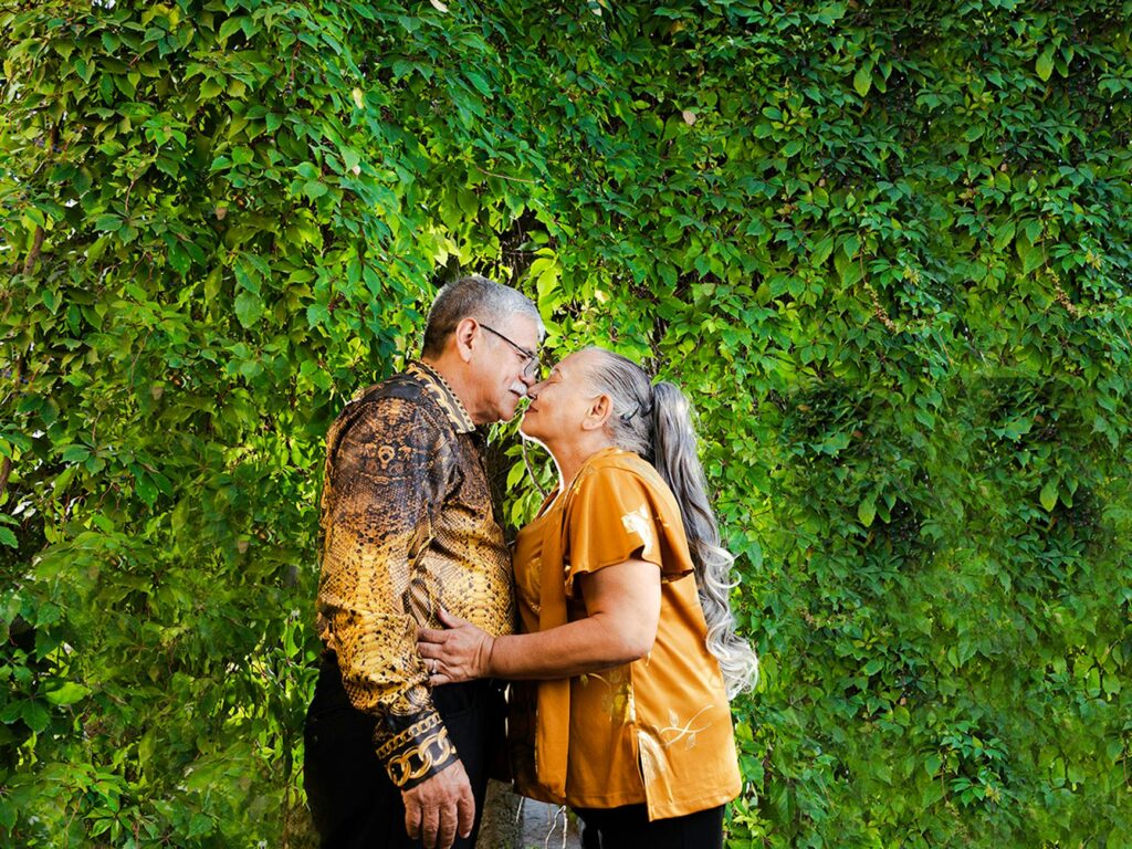 A couple sharing a kiss in front of a casino backdrop. — casino wedding packages Las Vegas