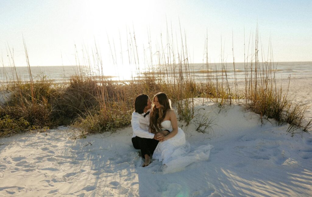 A couple writing their beach wedding invitations on a sandy beach — beach wedding invitation Las Vegas