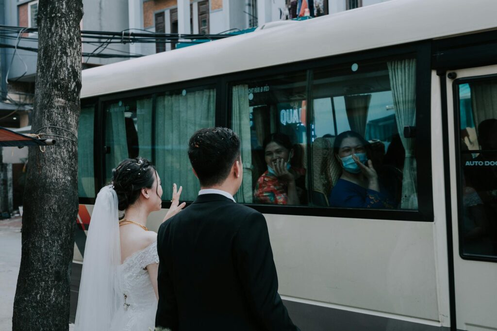 A group of guests boarding a budget-friendly shuttle bus decorated for a wedding event. — affordable wedding transportat…