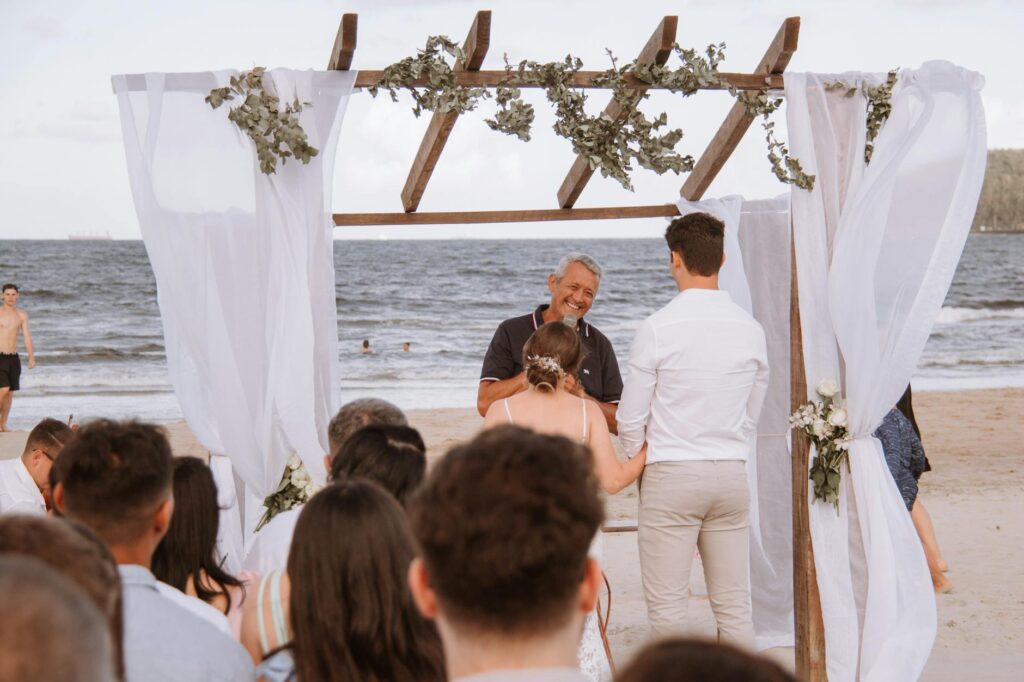 An officiant discussing details with a couple before their beach wedding ceremony starts. — beach wedding officiant Las …