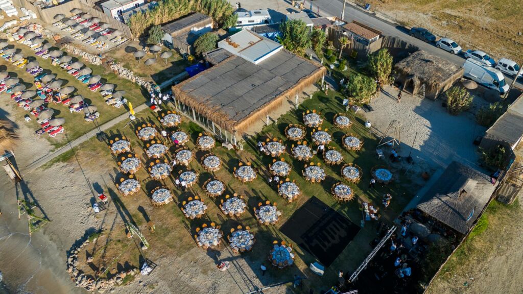 Guests enjoying a beach wedding reception, with tables set up near the shoreline. — destination beach wedding Las Vegas
