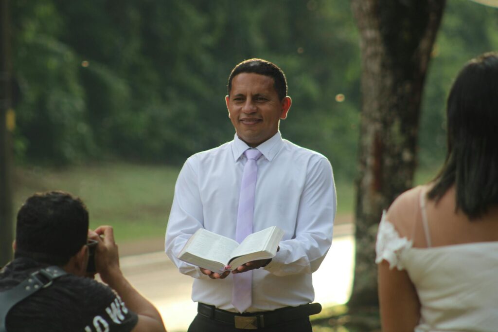 A close-up of a wedding officiant holding a ceremony script while standing with a couple. — Las Vegas wedding officiants