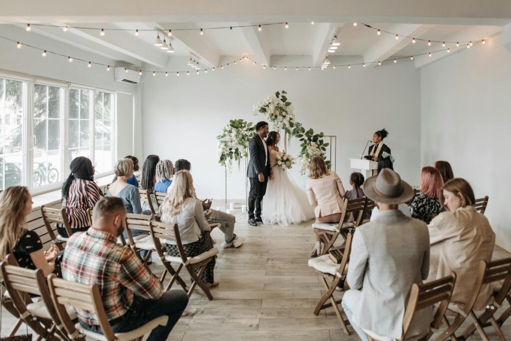 A couple discussing wedding plans with a Las Vegas wedding planner in a bright office setting. — questions for wedding p…