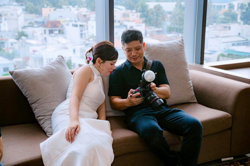 A couple looking at their wedding photos with a photographer in a candid moment. — Las Vegas wedding photographers