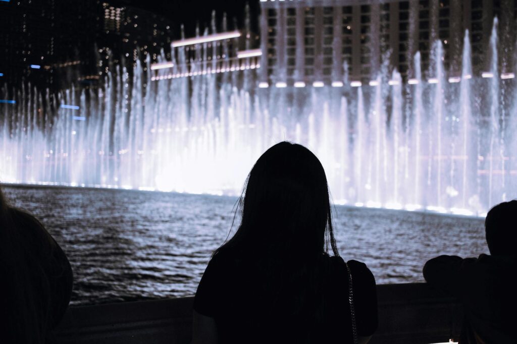 A couple posing against a famous Las Vegas landmark, like the Bellagio fountains, with a dreamy filter for a romantic vibe…
