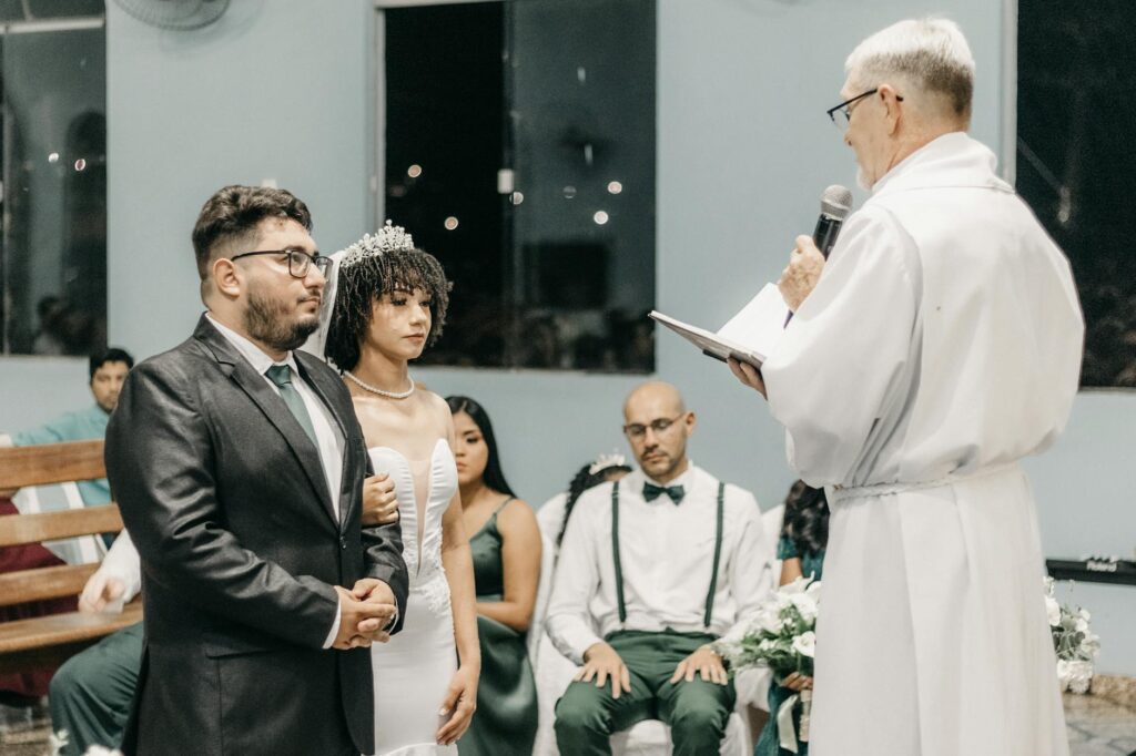 A wedding officiant dressed as Elvis performing a ceremony for a couple. — Las Vegas wedding packages
