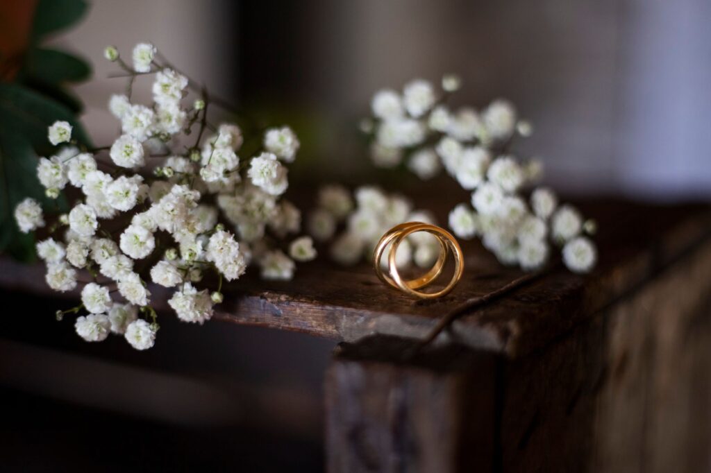 A close-up of wedding rings on a table decorated with flowers, representing intimacy. — elopement tips Las Vegas