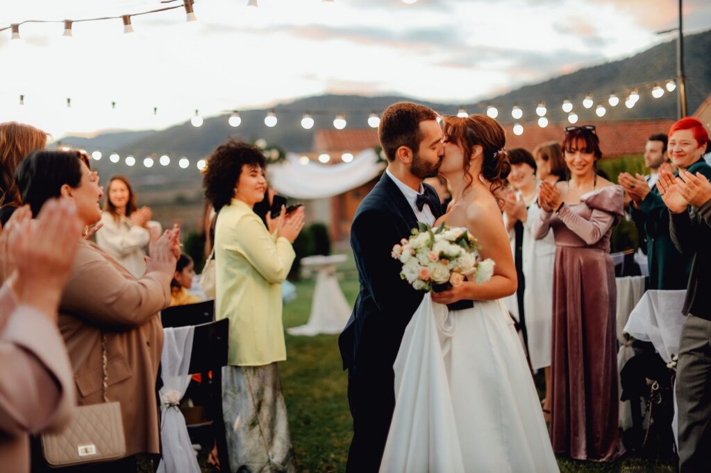 A couple celebrating their destination wedding at a unique venue, with guests enjoying interactive experiences. — unique…