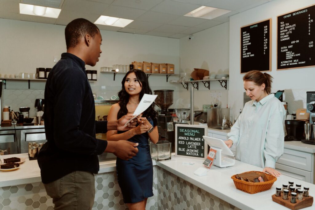 A couple discussing options with a wedding planner in a Las Vegas café. — best wedding vendors Las Vegas