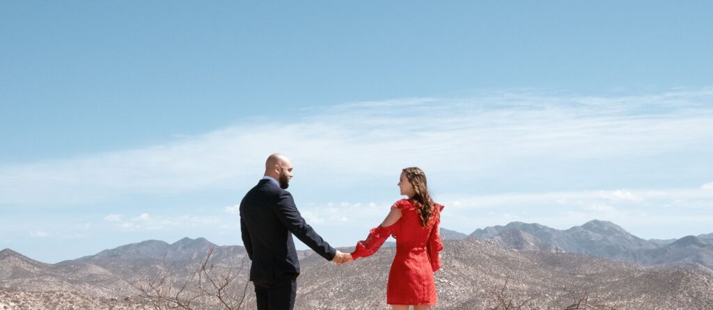 A couple holding hands with the Las Vegas skyline in the background. — destination wedding Las Vegas tips
