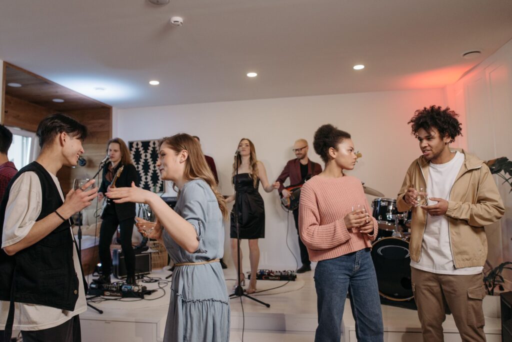 A group of happy guests mingling and enjoying live music at a welcome party. — las vegas wedding welcome party