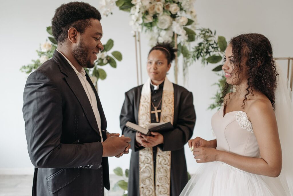 A happy couple exchanging vows with a Las Vegas wedding officiant in the background. — Las Vegas wedding officiants