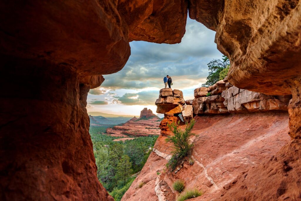 A picturesque view of Red Rock Canyon, with a couple posing against the dramatic red cliffs and desert landscape. — las …