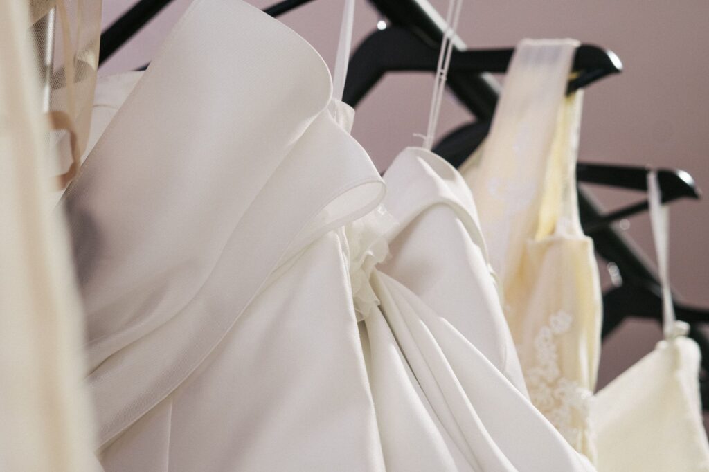 An array of wedding dresses and tuxedos on display in a bridal shop. — Las Vegas wedding planning checklist
