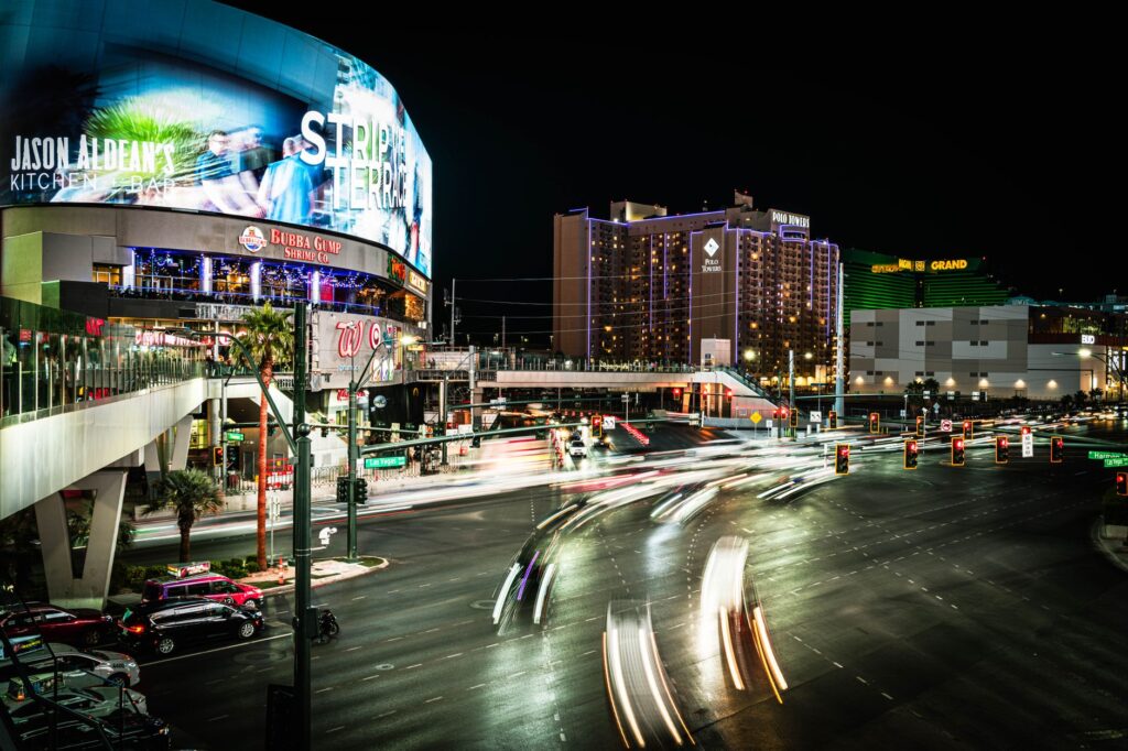 An artistic photo featuring a couple against the vibrant lights of the Las Vegas Strip, highlighting bold color palettes. …