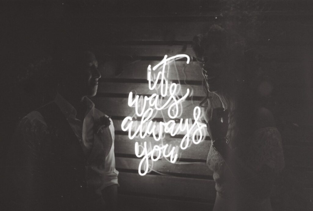 An elegant wedding portrait taken at the Neon Boneyard, featuring the couple amid the vintage neon signs. — las vegas we…