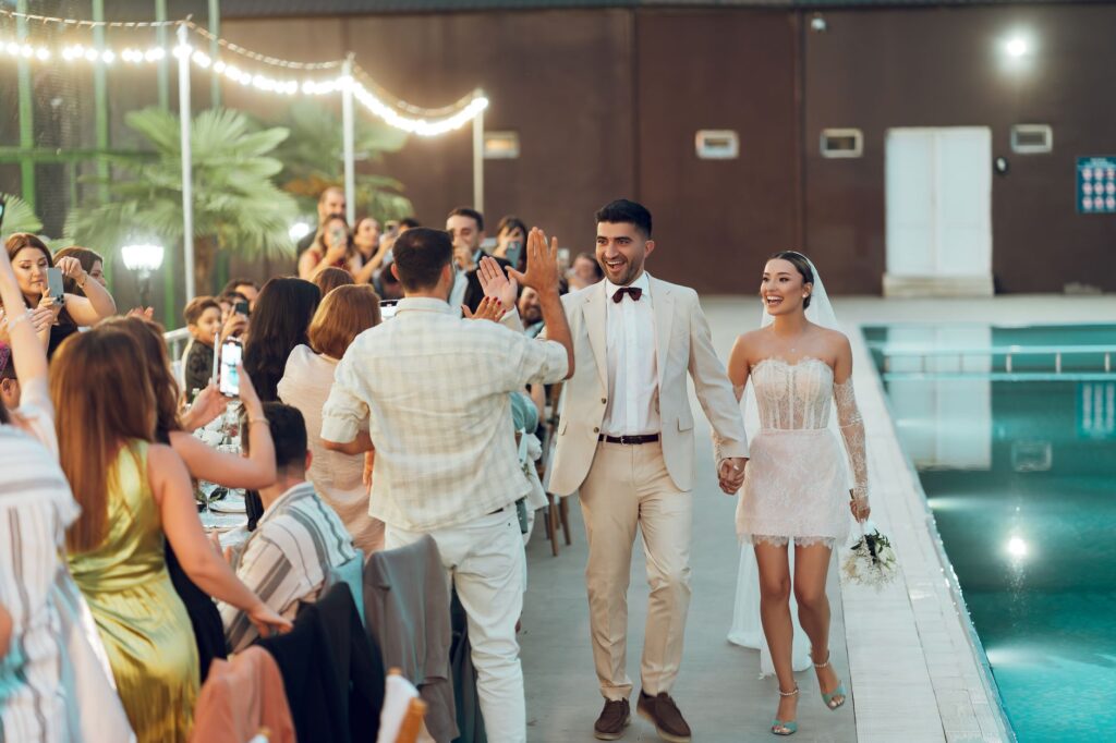 Couples enjoying a summer wedding celebration by the pool. — best time to marry in Las Vegas