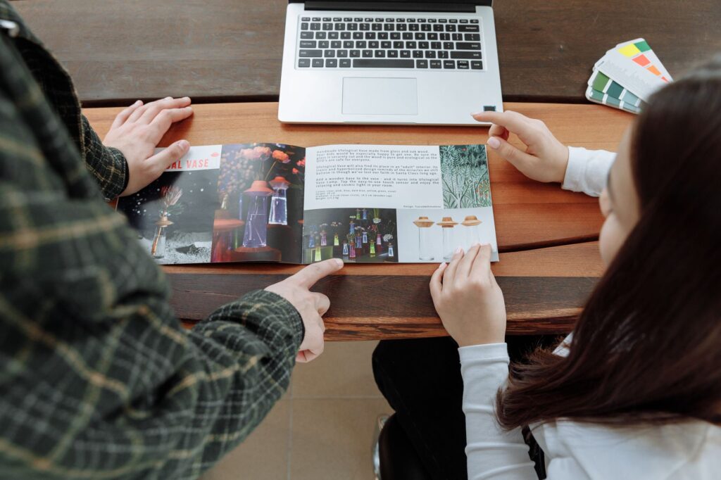 A couple looking at wedding venues in Las Vegas, with brochures and a laptop. — Las Vegas wedding planning checklist