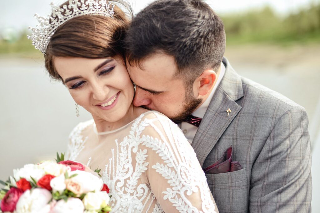 A couple smiling and enjoying a moment together during their wedding day with stress-free wedding day tips in mind