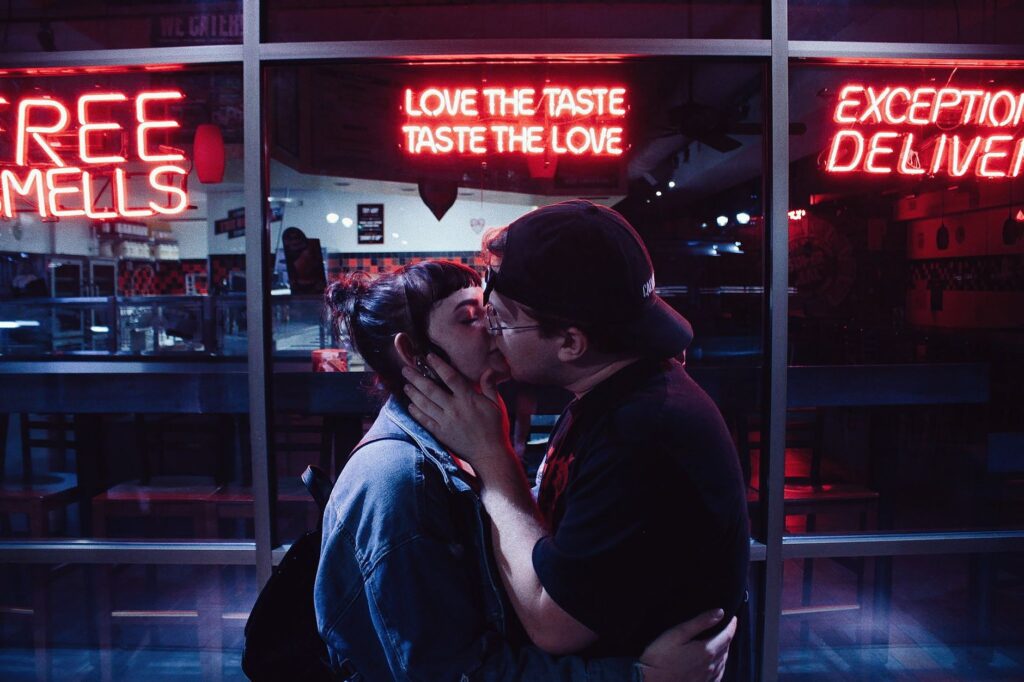 A happy couple sharing a kiss in front of a neon Las Vegas sign — Las Vegas elopement guide