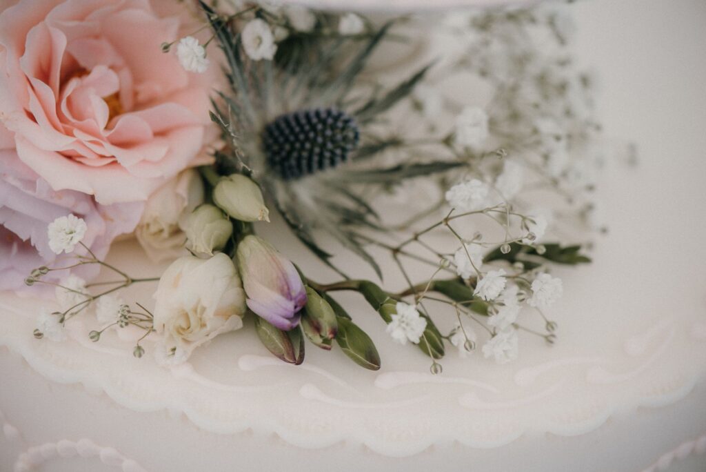 A close-up of a wedding cake decorated with flowers and elegant details. — Las Vegas wedding vendors