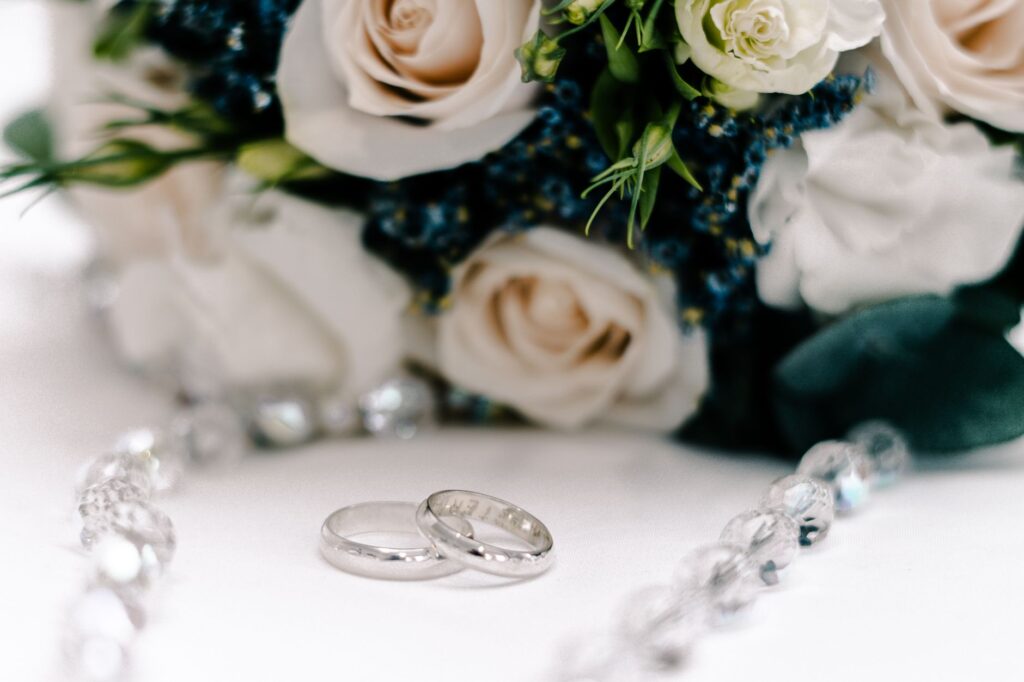 A close-up of wedding rings and flowers, symbolizing love and commitment in Las Vegas elopement planning.