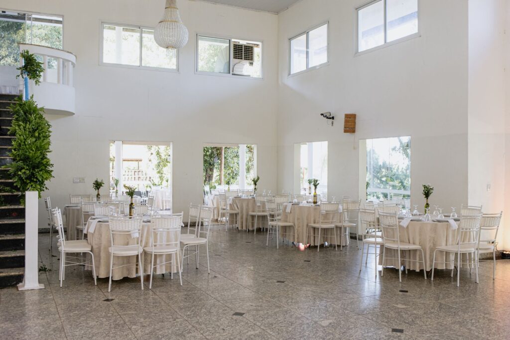 A couple discussing wedding details with a venue coordinator in a spacious hall. — questions for wedding venue