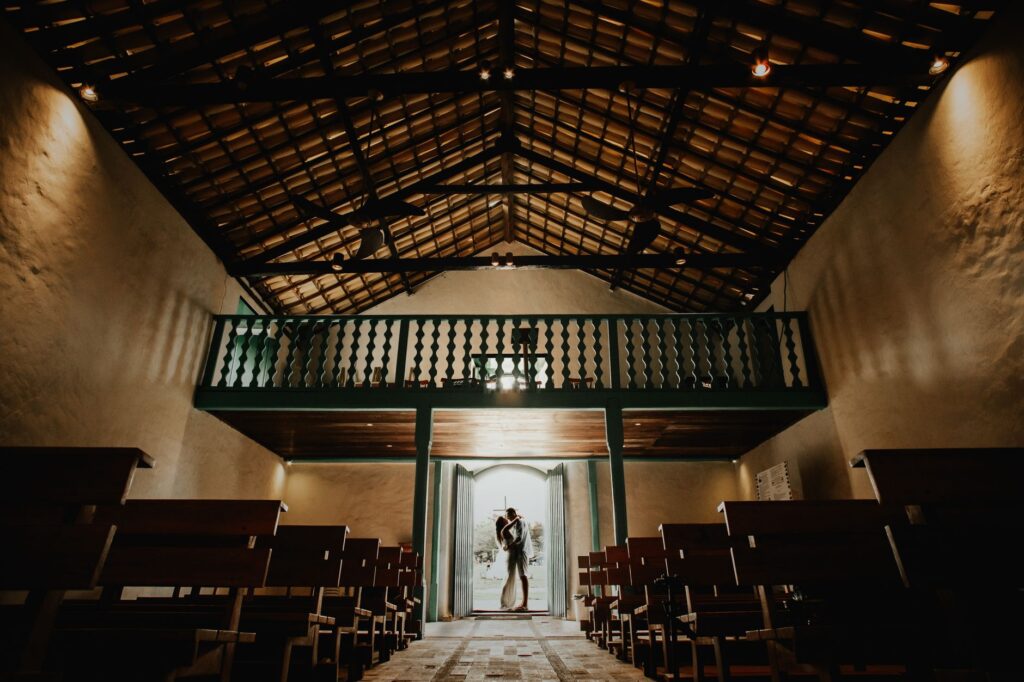A couple exchanging vows at The Little White Chapel, capturing the intimate atmosphere. — romantic wedding packages Las …