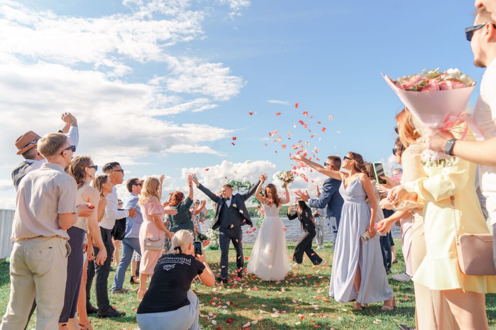 A couple exchanging vows under a clear blue sky in Las Vegas during summer, with guests enjoying the ceremony. — best ti…