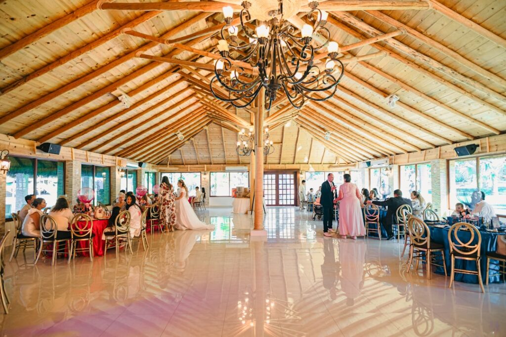 A glamorous summer wedding reception in a luxurious indoor venue, with elegant decor and guests enjoying themselves. — b…
