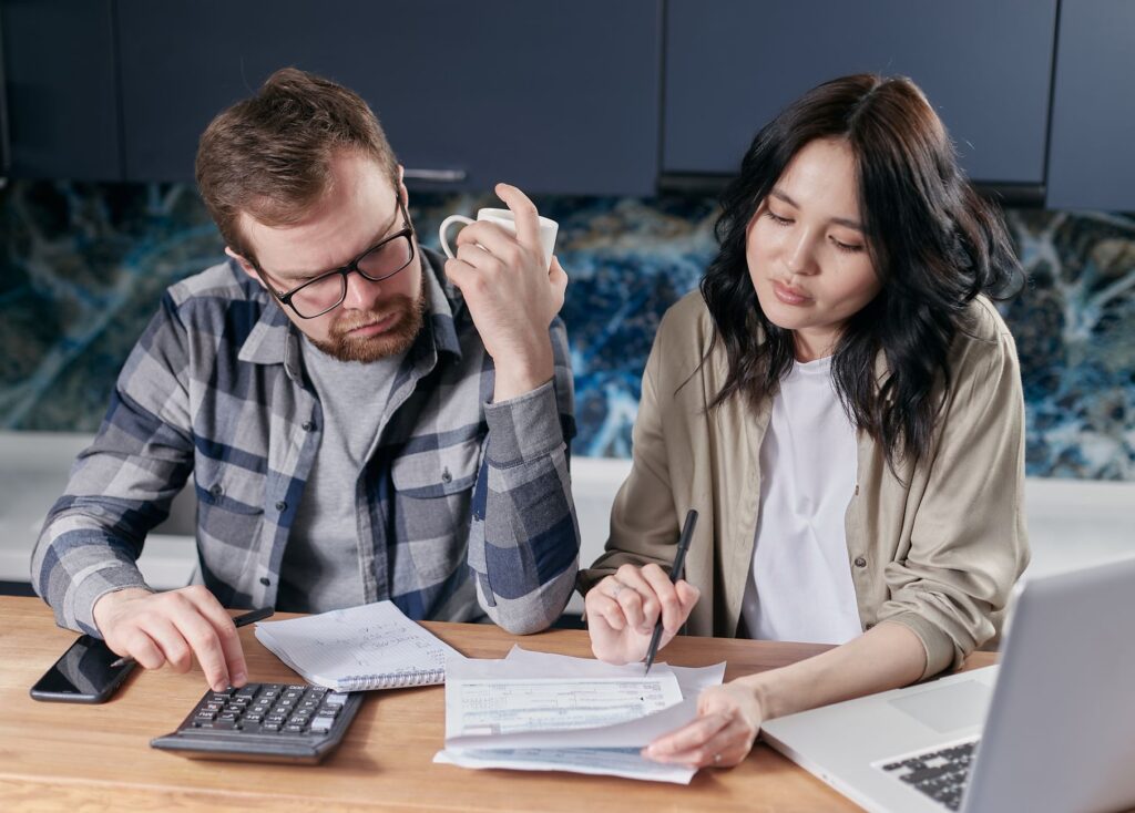 Couple planning their wedding budget with a calculator and notebook. — budget wedding Las Vegas