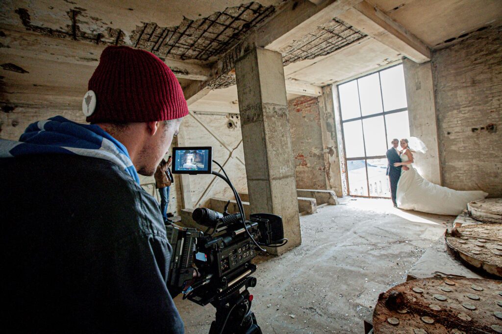A behind-the-scenes shot of a wedding photographer capturing a couple's first look. — best wedding photographers Las Vegas