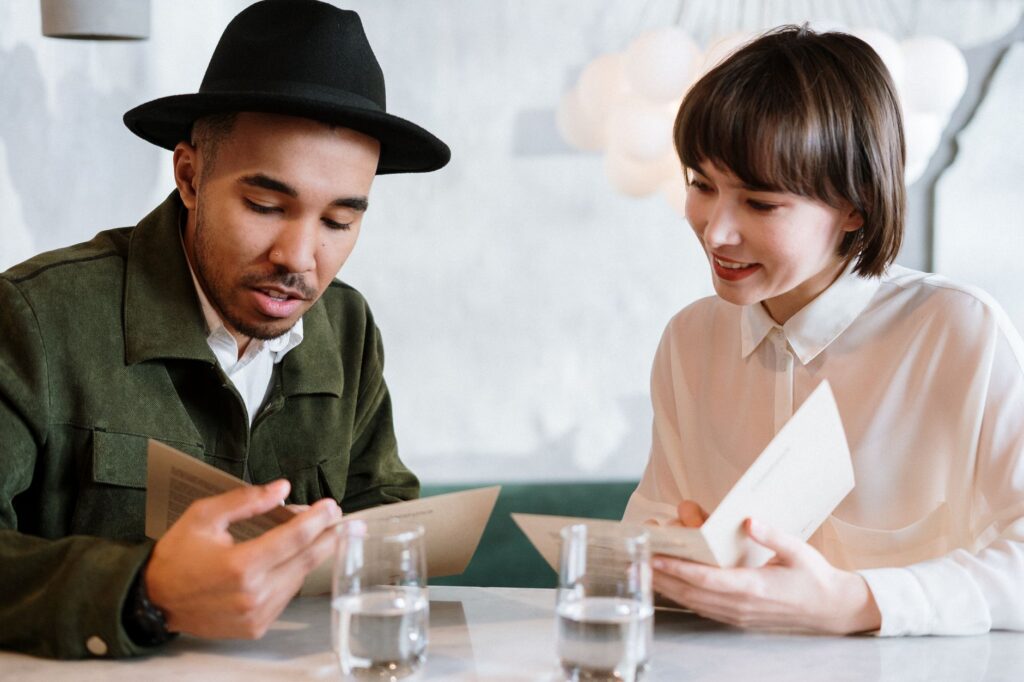 A wedding concierge discussing plans with a couple at a cafe. — wedding concierge services Las Vegas